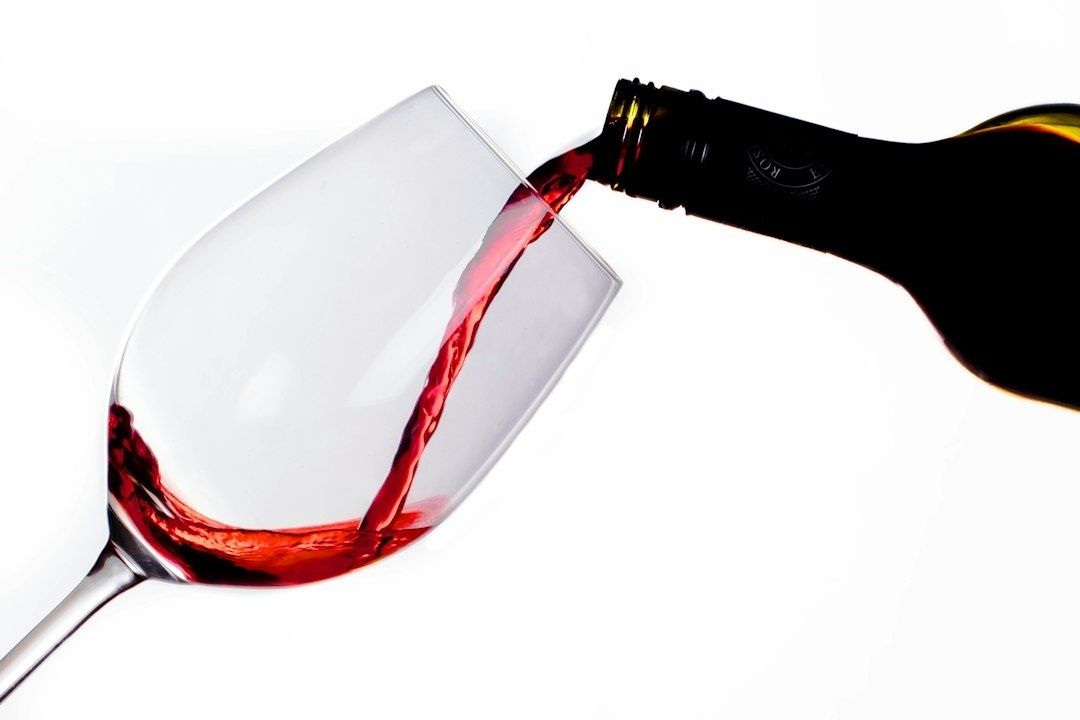 Rött vin hälls ur en flaska i ett vinglas